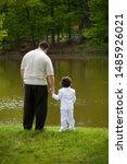 Small photo of Man and Boy overlooking pond