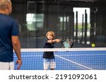 Small photo of Monitor teaching padel class to child, his student - Trainer teaches little boy how to play padel on indoor tennis court