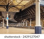 Small photo of York, UK. February 13, 2024. A railway station platform, lined by columns, curves, into a main concourse. A historic 19th Century canopy is overhead.