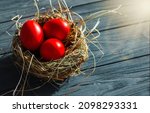 Small photo of colored deep red Easter eggs in nest top view background, selective focus image. Happy Easter card