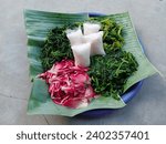 Small photo of pecel or traditional Indonesian food contains boiled torch ginger (Etlingera Elatior), boiled spinach, boiled kenikir plant (cosmos caudatus), boiled water spinach and rice cake. vegetable salad. top
