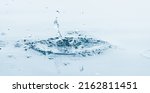 Small photo of isolated splashing water drops after plop on light blue, close-up of movement over the water surface, abstract water background concept in sunshine