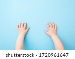 Baby hands on light blue table background. Pastel color. Closeup. Point of view shot.