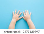 Baby boy hands on light blue table background. Pastel color. Closeup. Point of view shot.
