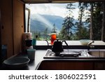 Interior of converted camper van or camping RV kitchen, coffee kettle and grinder stand on indoor table. Concept vanlife on the road, outdoor camp vibes for digital nomads