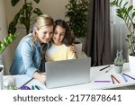 Small photo of Friendship of mom and her cute little daughter. They wallow at home in casual clothes and shopping online together using a laptop. They buy new toys for pretty little girl