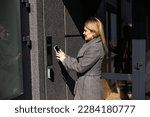 Smart home concept - close up of woman use mobile phone to open electronic lock