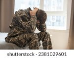 Nervous male military suffering depression, sitting alone at home, PTSD concept.