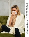Small photo of Yong blonde woman sitting on sofa with tussle napkin