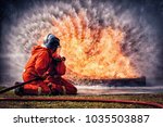 Small photo of Firefighter in fire fighting suit spraying water, Firemen fighting raging fire with huge flames of burning, Fire prevention and extinguishing concept