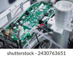 Small photo of Inside of an electronic device with a green electronic circuit board. A green PCB with many electronic components such as IC, resistor, capacitor,...