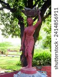 Small photo of Red Statue of Fisher Women With a fish in hand. Beautiful Statue of Fisher Women in Chambal Garden at Kora, Rajasthan, India 17 December 2023.