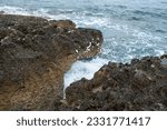 wild coastline on an island in Croatia. waves, dark rocks, blue sea.