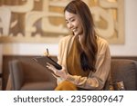 Small photo of Asian female executive do a comprehensive analysis while situated in a coffee shop, granting remote approval for a prospective investment project. Carefully devised strategic decision for expansion.