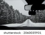 Drivers view in the rearview mirror reflection. winter season. Image of and through a car rear view mirror.  blizzard , snow storm.