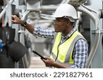 Small photo of Male plumber engineer inspecting quality of work at sewer pipes area at construction site. African American male engineer worker check or maintenance sewer pipe network system at rooftop of building