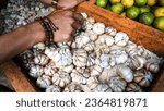 Small photo of Close up of fresh garlic on sale at a vegetable seller's table in a traditional market, one of the healthiest spices.