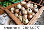 Small photo of Close up of fresh onions being sold on a vegetable seller's table in a traditional market, one of the healthiest spices.