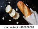 Sliced french baguette with crumbs on black background. Traditional fresh bread for breakfast
