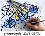 Small photo of A woman draws a neurographic drawing on paper with color pencils. Neurographic art is an easy way to work with the subconscious mind through drawing. Taking care of yourself