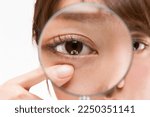 Small photo of Enlarge the woman's lower eyelid with a magnifying glass.