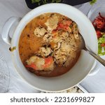 Small photo of Delicious dogfish moqueca with tomatoes, coconut milk and red, green and yellow peppers displayed in a white porcelain casserole dish.