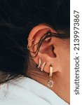 Small photo of Close up of the woman with multiple piercings on the ear