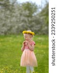 Small photo of Portrait of beautiful towheaded girl with dandelion wreath on the meadow. Vertical frame. Blurred background