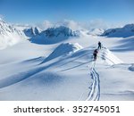 High altitude view of two skiers walking on a mountain ridge in the Lyngen Alps, Norway