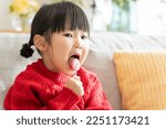 Asian child licking a lollipop