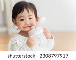 Small photo of A 9-month-old baby drinking water from a mug.