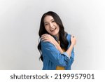 Small photo of Self care and self esteem concept, Happy young beautiful Asian woman in colorful clothing hugging herself isolated on white background. People emotion portrait concept.
