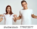 cheerful young couple in white t-shirts on a light background, logo                               