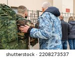Small photo of 09.30.2022 Russia Moscow people with things, soldiers stand at the gates waiting for mobilization. A young couple, a guy and a girl, say goodbye before going to war. High quality photo