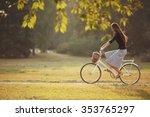 Beautiful smiling girl is riding the bicycle in the park