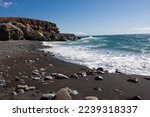 Ajuy beach, made up of black volcanic sand and stones, located on the west coast of Fuerteventura
