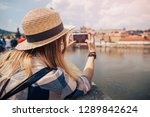 Young woman happy with backpack tourist taking selfie photo camera on Charles Bridge in Prague, Czech Republic. Concept travel.
