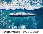 Combat military nuclear diesel electric submarine on background of blue ocean water. Top view aerial drone.
