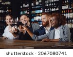 Small photo of African woman and European men are mingled with glasses of red wine in restaurant. Concept Multicultural friendship.