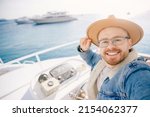 Small photo of Portrait smile happy man driver captain of white luxury yacht holding helm wheel, summer travel on boat sea.