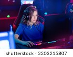 Young caucasian woman pro gamer streamer playing in online video game, neon color soft focus.