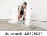 Small photo of Leveling with mixture of cement for floors. Worker use screed concrete epoxy for level.