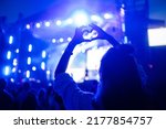 Small photo of Heart shaped hands at concert, loving the artist and the festival. Music concert with lights and silhouette of people enjoying the concert.