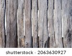 Small photo of old wooden fence made of rough and uncouth planks, darkened with time, in daylight, isolated on white background