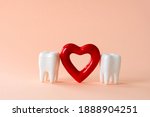 Two teeth and red heart on a pastel background. Oral care and St. Valentine's day concept.
