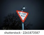 Give Way UK Road sign at night with blurred background