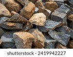 Small photo of fragments of a neatly arranged pile of macadam stones.