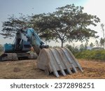 Small photo of Tulungagung, Indonesia - October 08, 2023: Excavator is in an empty field, shot from the front. An excavator or dredging machine is heavy equipment that is usually used for excavation (excavation).