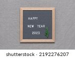 Happy New Year 2023 lettering board. Gray felt letter board. Gray textile background. Top view, flat lay.