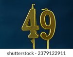 Small photo of close up on the gold number forty-ninth candle on a dark background.